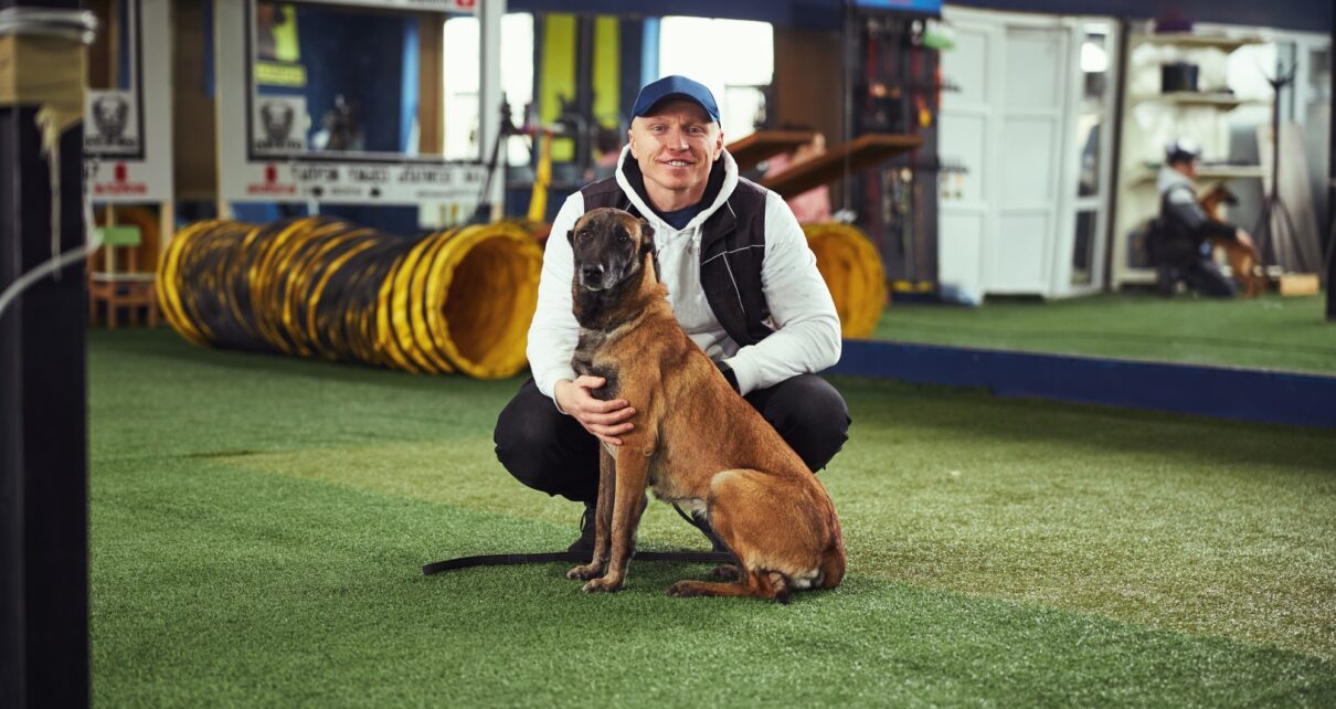 Instructor posing for the camera with a calm adult dog