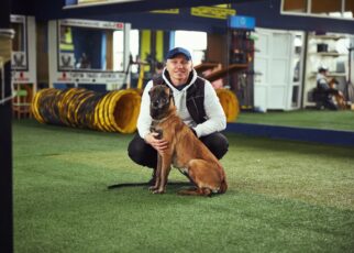 Instructor posing for the camera with a calm adult dog