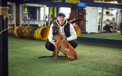 Instructor posing for the camera with a calm adult dog