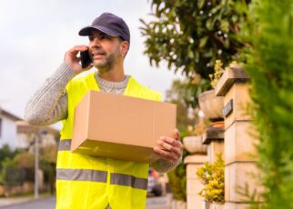 Package delivery carrier with a box from an online store, calling the customer