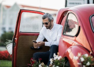 The man writes sms in the red oldtimer