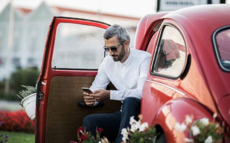 The man writes sms in the red oldtimer