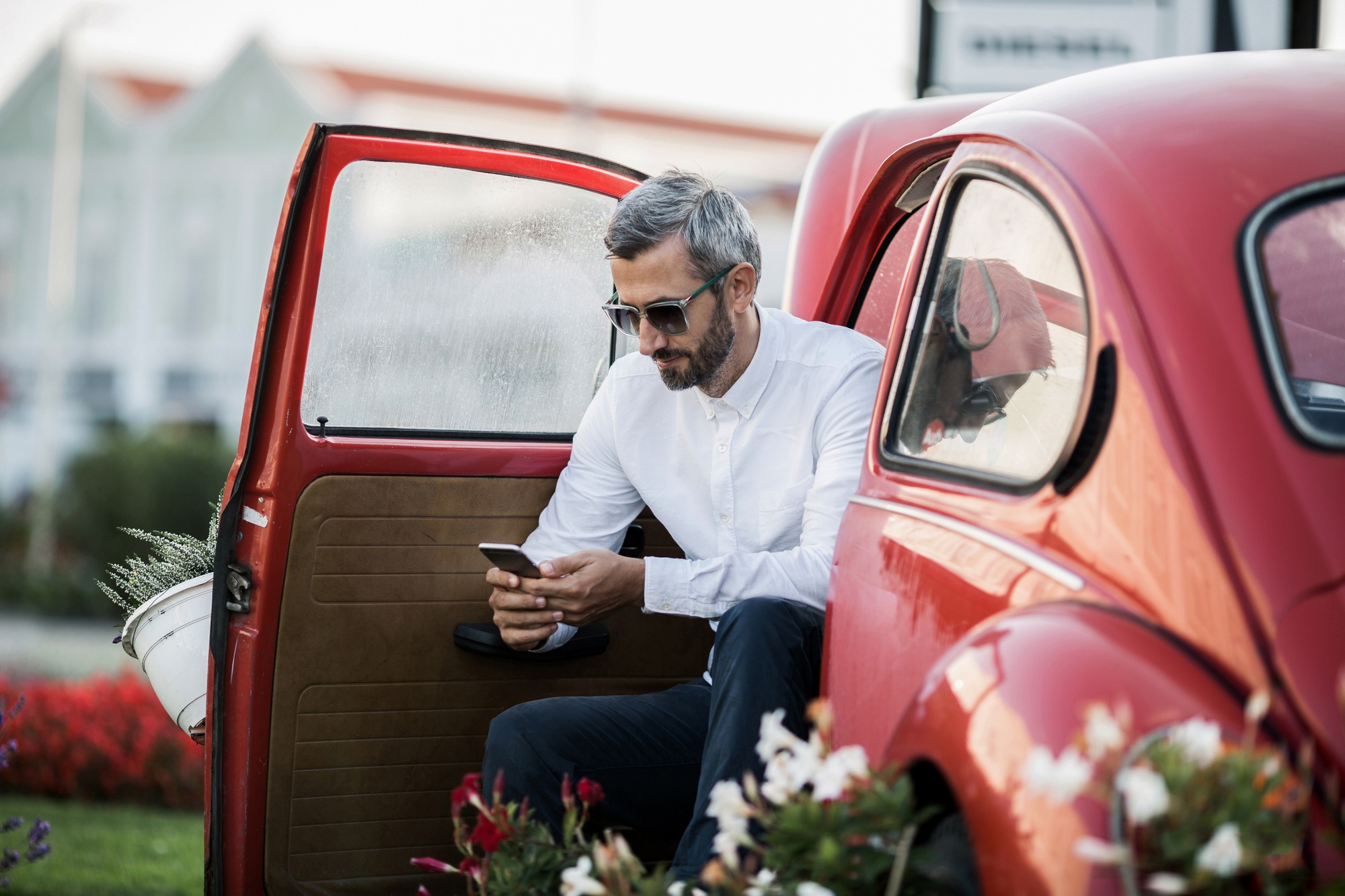 The man writes sms in the red oldtimer