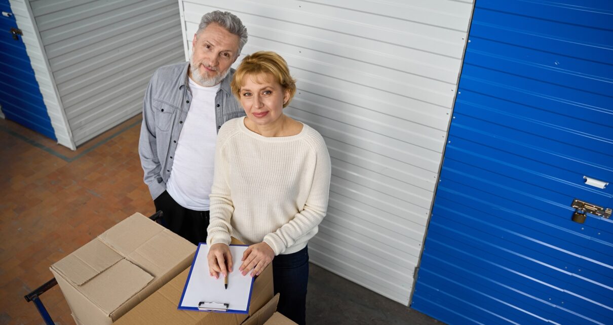 Woman notes information of storage boxes standing near client