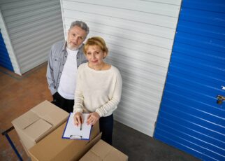 Woman notes information of storage boxes standing near client