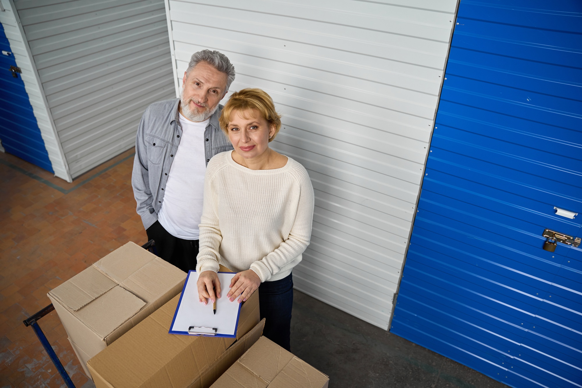 Woman notes information of storage boxes standing near client