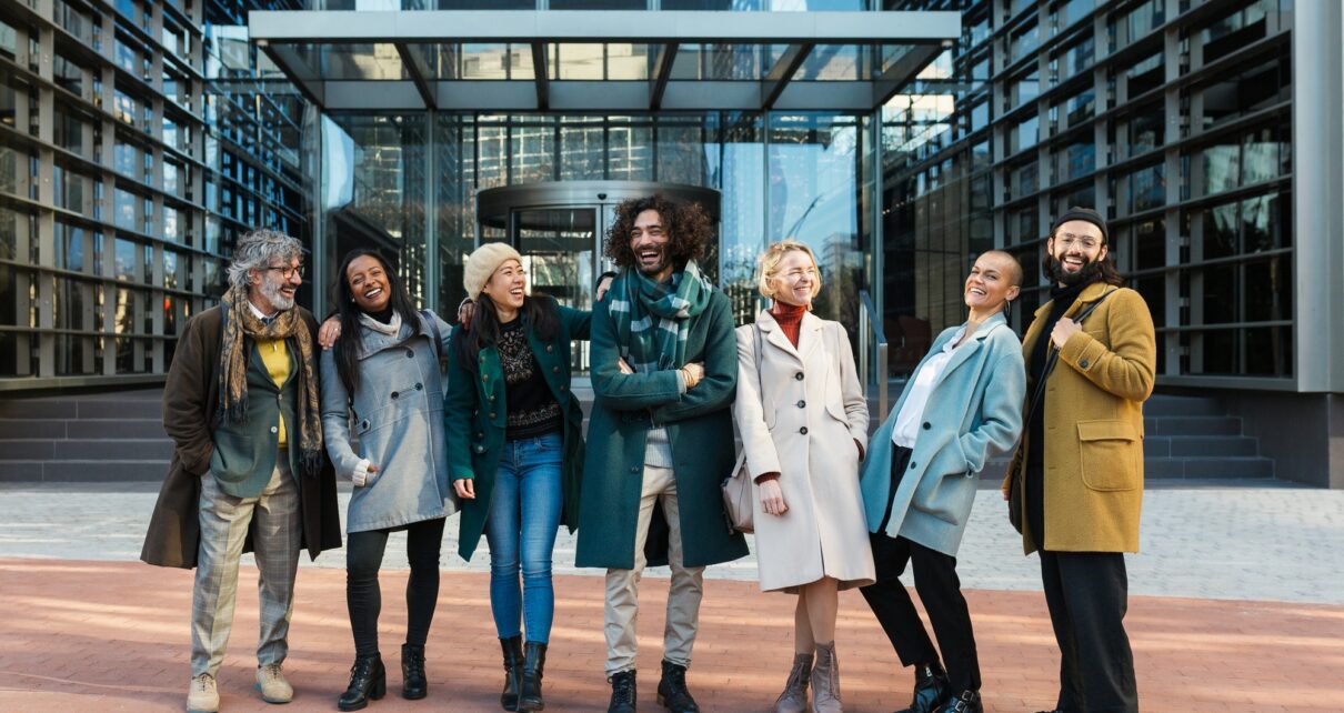 Diverse coworkers laughing on street before work together