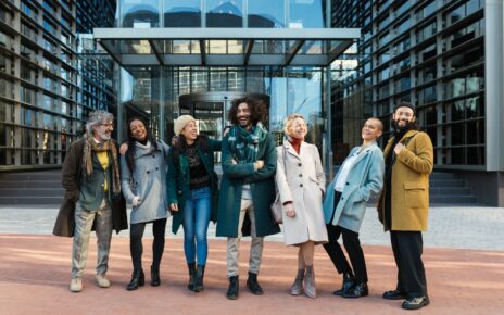 Diverse coworkers laughing on street before work together