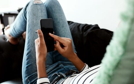 And send...Cropped shot of a woman using a smartphone on the sofa at home.