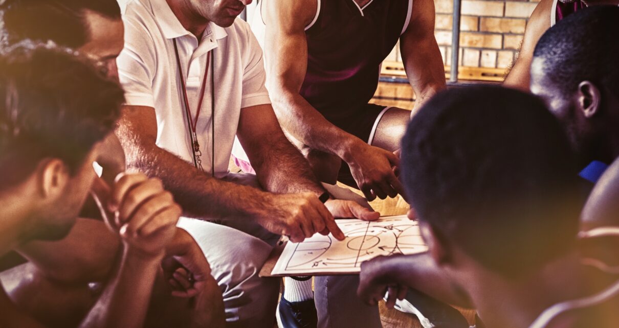 Coach explaining game plan to basketball players