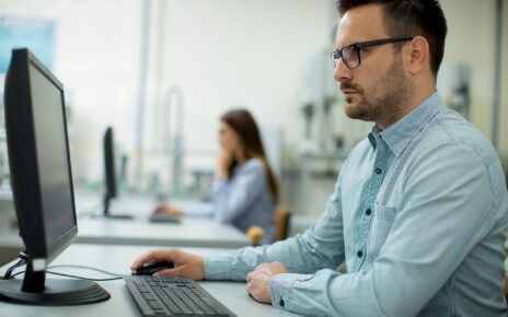 Side view of focused students using desktop pc in classroom